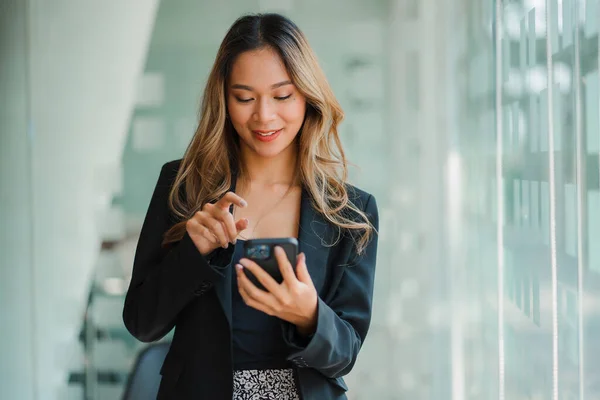 Freelance Asian woman working on smartphones and tablet computers in a modern office. make an account analysis report on real estate investment information financial and tax system concepts