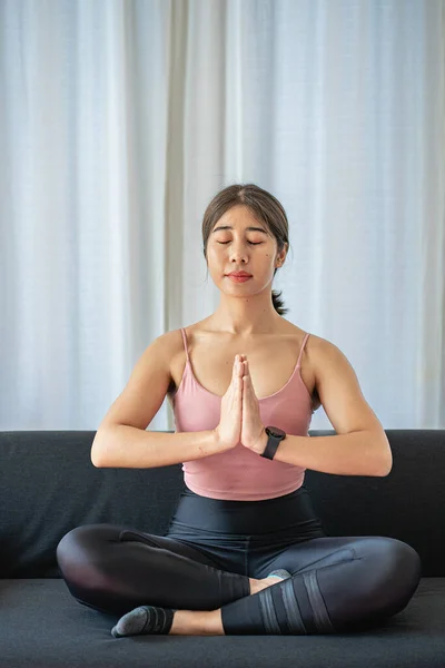 Quiet Asian girl doing yoga in the living room yoga and meditation concept morning meditation Asian girl practicing yoga at home