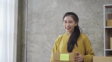 Online SME business owner, young lady, Asian line, selling stuff with Kong. Checking stock and working with a laptop at home. Small business owners at online selling ideas.