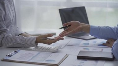 İki iş adamı masalarında mali tabloyla el sıkışıyorlar. El ele tutuşuyorlar. İki işadamı bir iş anlaşması yapmak için bir projeyi tartışıyor ve el sıkışıyorlar..