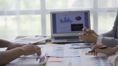Statistical analysis of 3 business people on business data in a meeting graph on a laptop analyzing data. A coworker is overworked while brainstorming documents and graphs to present a 4k solution.