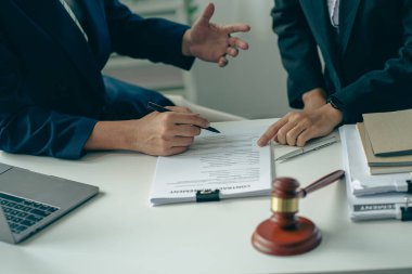 Profesyonel iş kadınları ve erkek avukatların yargıcın çekiçli ofisinde çalışarak ve tartışarak adalet terazisinin yanı sıra hukuk ve danışmanlık hizmetleri kavramını da içeren bir toplantı..