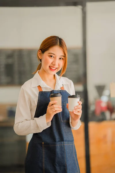 Barista, coffee shop owner waitress Asian woman holding a coffee cup serving customers at a coffee shop Start Food and Beverage Small Business Owner Ideas