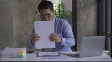 Genç Asyalı işadamı gelir ve giderleri hesaplamak için hesap makinesiyle muhasebe işi yapıyor, vergiler, faturalar, ödeme için kredi kartları ya da evdeki, işyerindeki, finansal konseptlerdeki, 4k video.