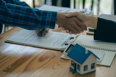 The sales agent offers the customer a home purchase contract to purchase the property, a handshake between the sales agent and the landlord when signing a home purchase or rental contact.