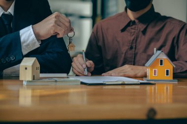 home sales representative holding keys by businessman The agent gives the key to the customer. Home Buying and Home Insurance Ideas