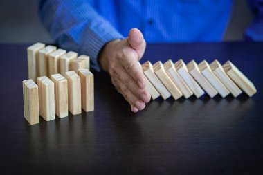 İş Riskleri ve Stratejileri el ele vererek, düşen tahta blok domino taşlarının savunma ve güvenlik önleme ve sorun çözme kavramlarının geliştirilmesinin sonuçlarını durdurur