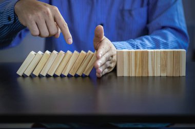 İş Riskleri ve Stratejileri el ele vererek, düşen tahta blok domino taşlarının savunma ve güvenlik önleme ve sorun çözme kavramlarının geliştirilmesinin sonuçlarını durdurur