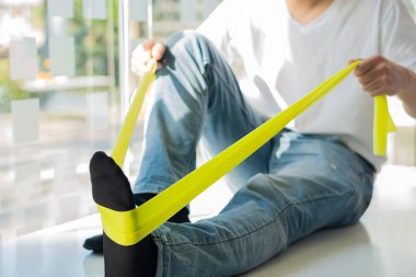 Fizyoterapi rehabilitasyon bando terapisi sağlar. rehabilitasyon merkezinde genç bir erkek hasta.