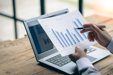 Finansal istatistikler, stok fotoğrafları, tartışma ve veri analizleri, grafikler, şemalar, şemalar, iş yerleri ve iş kavramlarını içeren belgeleri elinde tutan işadamı.