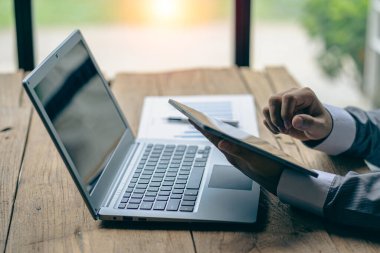 Businessman holding documents containing financial statistics, stock photos, discussion and data analysis, charts and graphs, charts, diagrams, business, and work concepts.