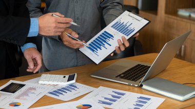 Finansal istatistikler, stok fotoğrafları, tartışma ve veri analizleri, grafikler, şemalar, şemalar, iş yerleri ve iş kavramlarını içeren belgeleri elinde tutan işadamı.