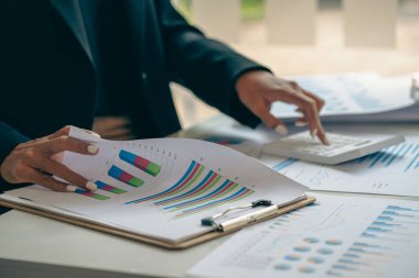 Finansal istatistikler, stok fotoğrafları, tartışma ve veri analizleri, grafikler, şemalar, şemalar, iş yerleri ve iş kavramlarını içeren belgeleri elinde tutan işadamı.