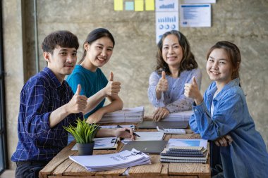 Toplantı programı yeni iş fikirlerini başlatır. İş arkadaşları buluşması yaratıcılığın beyin fırtınası yapar. Genç Asyalılar Stratejik Tema Birlikte çalışarak Ofis Masasında Mali Verileri Analiz Eder
