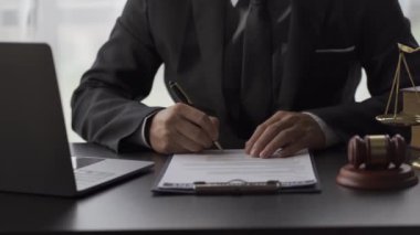 Yargıç, yargı kurulunu ve adalet ve hukuk kavramını yumrukluyor. Yargıç, yanında çekiç, pul ve dizüstü bilgisayarla mahkeme salonunda, 4k video.