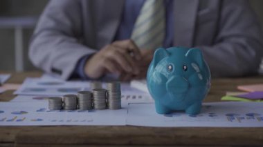 Para yığını ve kumbaralar iş adamlarının önüne serildi. Para hesapları, 4K video.