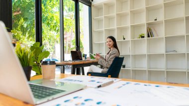 Asyalı iş kadını çalışıyor, çizelge, tartışma ve veri analizi. Çizelgeler ve grafikler ve hesap makinesi kullanarak rakamları hesaplamak ofisteki iş finans ve muhasebe kavramları.