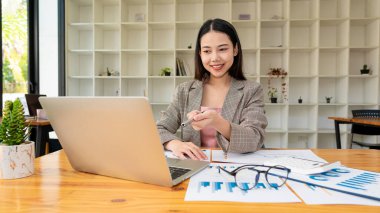 Asyalı iş kadını çalışıyor, çizelge, tartışma ve veri analizi. Çizelgeler ve grafikler ve hesap makinesi kullanarak rakamları hesaplamak ofisteki iş finans ve muhasebe kavramları.