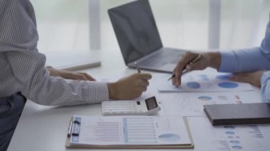 2 business people looking at financial charts in notebooks cheerful man analyzingWork in the office Gadgets and documents with graphs and data 4k video