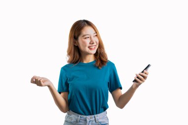 Beyaz arka planda cep telefonu tutan ve el kol hareketi yapan sevimli Asyalı kadın..