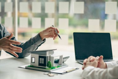 The sales representative offers a home purchase contract to purchase a house or apartment. Or talk about loans and interest rates and insurance, real estate concepts.