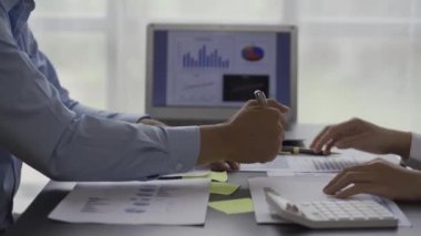 İş ekibi verileri analiz eden bir dizüstü bilgisayardaki toplantı grafiğinde iş verilerinin istatistiksel analizi. İki iş arkadaşı, çözüm sunmak için beyin fırtınası yapan belgeler ve grafikler üzerinde çok çalışıyor. 4k video