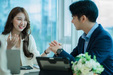 Finansal Grafik bilgisayar ofisinde birlikte çalışan iki genç Asyalı iş adamı. Fikirlerinizi paylaşın, iş planlarınızı tartışın ve eğitin..