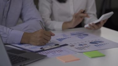 Businessmen, 2 men and women look at financial analysis charts. work in the office and documents with graphs and data, 4k video