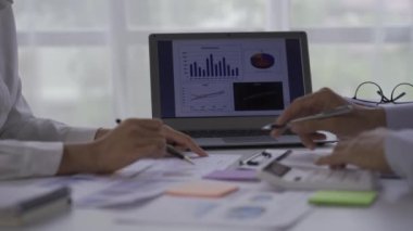 Businessmen, 2 men and women look at financial analysis charts. work in the office and documents with graphs and data, 4k video