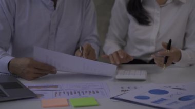 Businessmen, 2 men and women look at financial analysis charts. work in the office and documents with graphs and data, 4k video