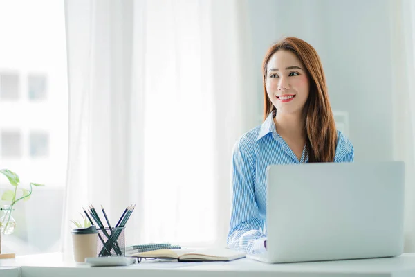 beautiful asian business woman Millennial professional female financial analyst working on financial charts and chart data with laptop in the office.