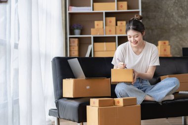 Small Business Startup SME Owners Asian Women Also Check Online Orders Laptops and sales of work items with girl boxes. Work independently at home, online SME business, small and medium enterprises