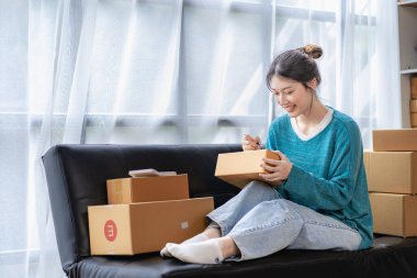 Small Business Startup SME Owners Asian Women Also Check Online Orders Laptops and sales of work items with girl boxes. Work independently at home, online SME business, small and medium enterprises
