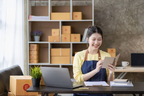 Small Business Startup SME Owners Asian Women Also Check Online Orders Laptops and sales of work items with girl boxes. Work independently at home, online SME business, small and medium enterprises