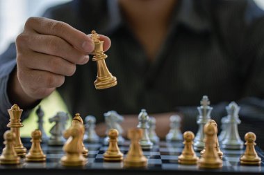 Close-up of confident businessman playing chess game to analyze development new strategic plan Leadership and Teamwork Ideas for Business Success