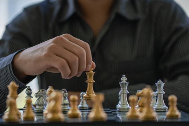 Close-up of confident businessman playing chess game to analyze development new strategic plan Leadership and Teamwork Ideas for Business Success
