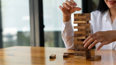 Solutions and Strategies Businesswoman placing or pulling wooden blocks on the tower business planning ideas risk management