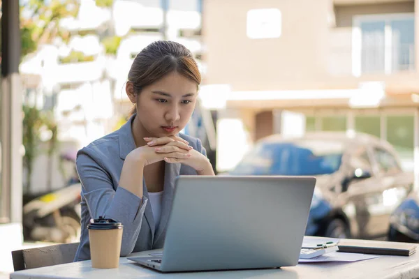 Professional Asian female accountant or financial clerk at her job who works on financial reports. and laptop computers and