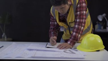 Architects and engineers meet or discuss blueprints in meetings in the construction site office.