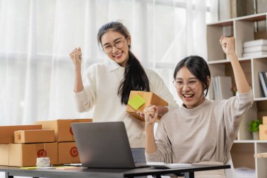 Two independent Asian women working from home small business owners inspect products before delivering them to customers online. shipping packaging Online marketing for SMEs, startups, concepts