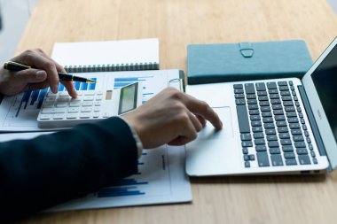 Businessman financial analysis with laptop and accounting report graph with calculator