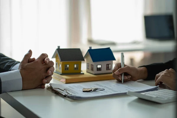 Home agents talk to new home buyers and offer good interest rates and calculate clients on mortgage financing to help make real estate concept decisions.