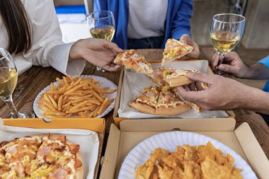 Group of male and female colleagues having pizza lunch together at the office after work celebration concept