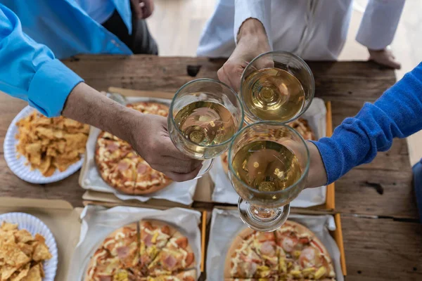 Group of male and female colleagues having pizza lunch together at the office after work celebration concept