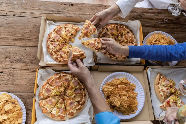 Group of male and female colleagues having pizza lunch together at the office after work celebration concept