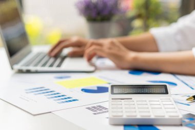 Close up hand man doing finance and calculate on desk about cost at home accountant working on desk using calculator for calculate finance report in office
