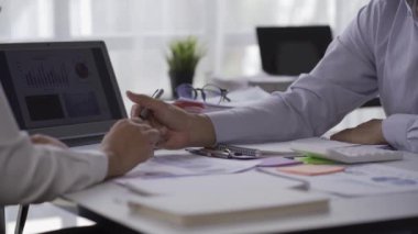 Two Asian businessmen and businesswomen analyze data on graphs of rising finances, sales, revenues and profits during meetings in a conference room at a modern office. 4k