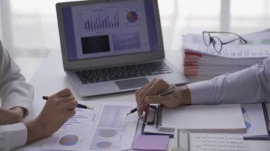 Two Asian businessmen and businesswomen analyze data on graphs of rising finances, sales, revenues and profits during meetings in a conference room at a modern office. 4k