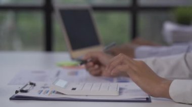 Two Asian businessmen and businesswomen analyze data on graphs of rising finances, sales, revenues and profits during meetings in a conference room at a modern office. 4k