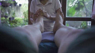 Woman having a relaxing massage in a Thai shop massage therapist doing reflexology A professional masseuse is doing a traditional Thai massage for body treatment. relaxation and recovery of the body